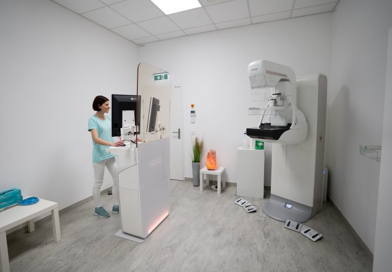 Mammographie-Untersuchungsraum in der Radiologiepraxis Oberpullendorf mit moderner Röntgeneinheit und medizinischem Personal am Computer.