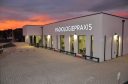 Abendliche Außenansicht der Radiologiepraxis Oberpullendorf mit leuchtendem Praxisschild und wunderschönem Sonnenuntergang
